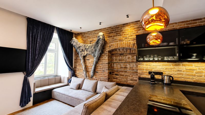 Design-Innenraum einer 2-Zimmer-Wohnung mit Ziegelwand und bequemer Couch.