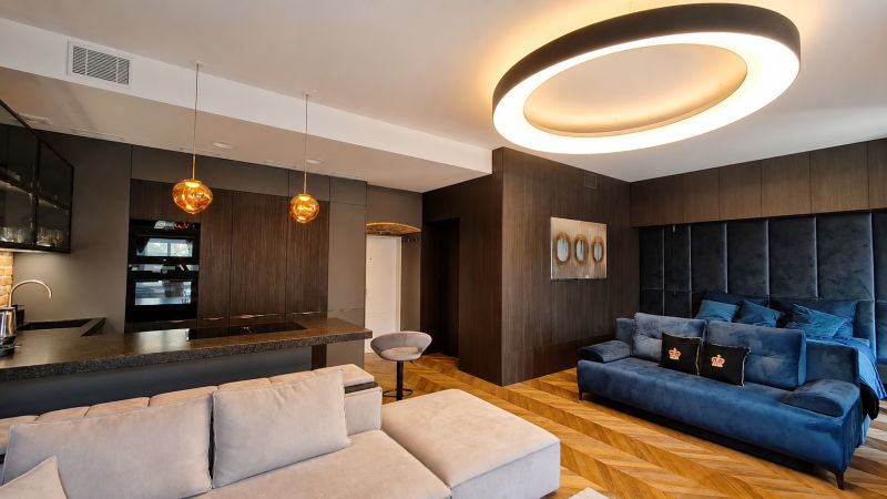 Wohnzimmer in einer 2-Zimmer-Wohnung mit Holzboden und interessanter Beleuchtung.