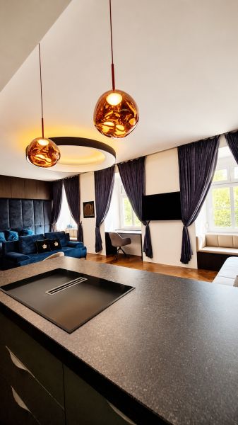 Innenraum einer 2-Zimmer-Wohnung mit eingebauter Beleuchtung, Vorhängen und einem Boden in Holzoptik.
