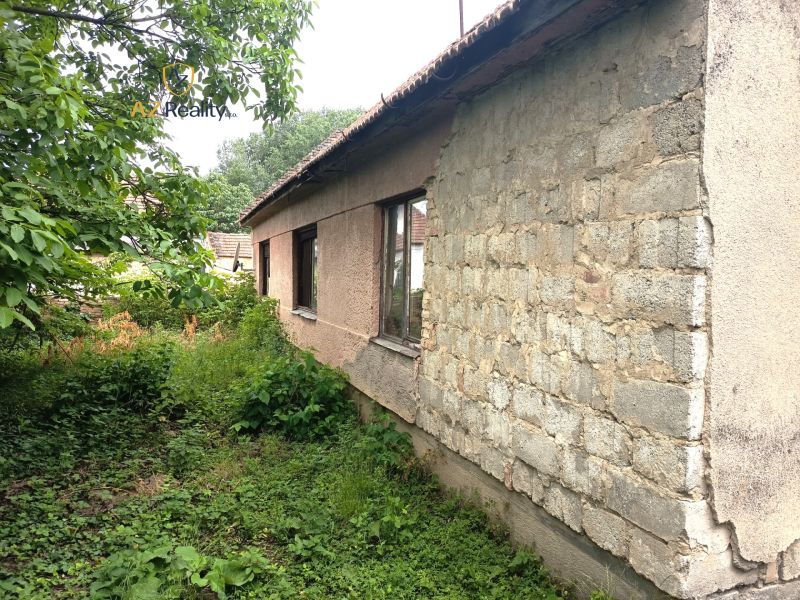 Ein älteres Familienhaus in Nové Zámky mit einem ungepflegten Garten und einer Holzdachkonstruktion.