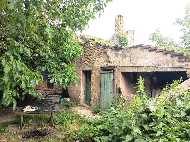 Ein altes Familienhaus in Nové Zámky mit einem vernachlässigten Garten und einem beschädigten Dach.
