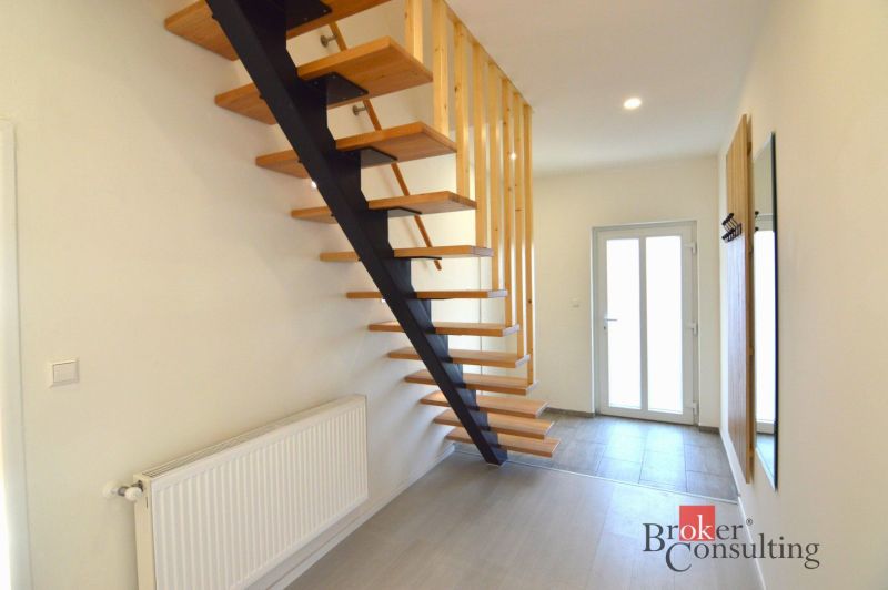Treppe mit Holzboden, Eingang und Heizkörper in einer 2-Zimmer-Wohnung.