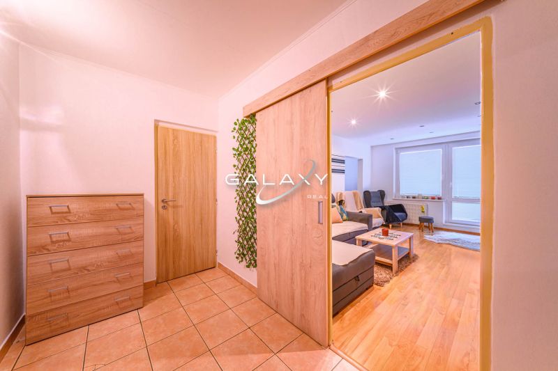 Wohnzimmer einer 2-Zimmer-Wohnung mit Holzboden und Eingangshalle.