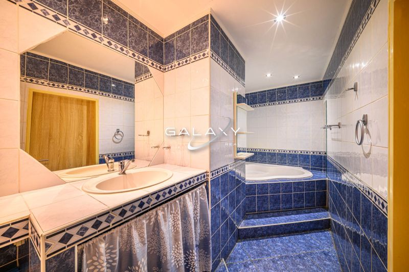 Badezimmer mit blauen Fliesen und zwei Waschbecken in einer 2-Zimmer-Wohnung.