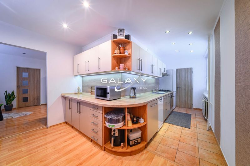 Küche in einer 2-Zimmer-Wohnung mit Holzboden und modernen Geräten.
