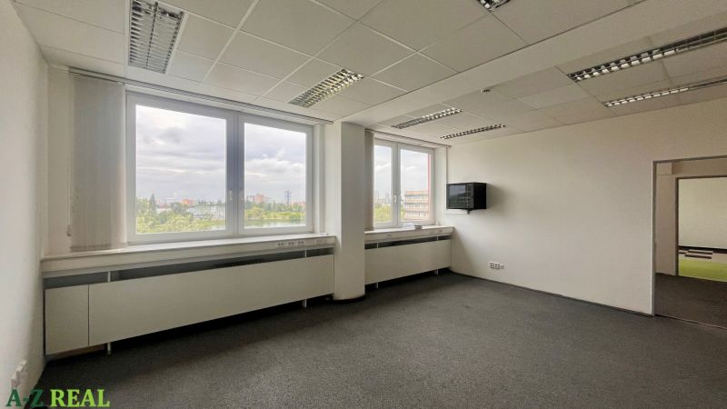 Büros mit großen Fenstern und Aussicht, einfache Einrichtung, neutrales Interieur.