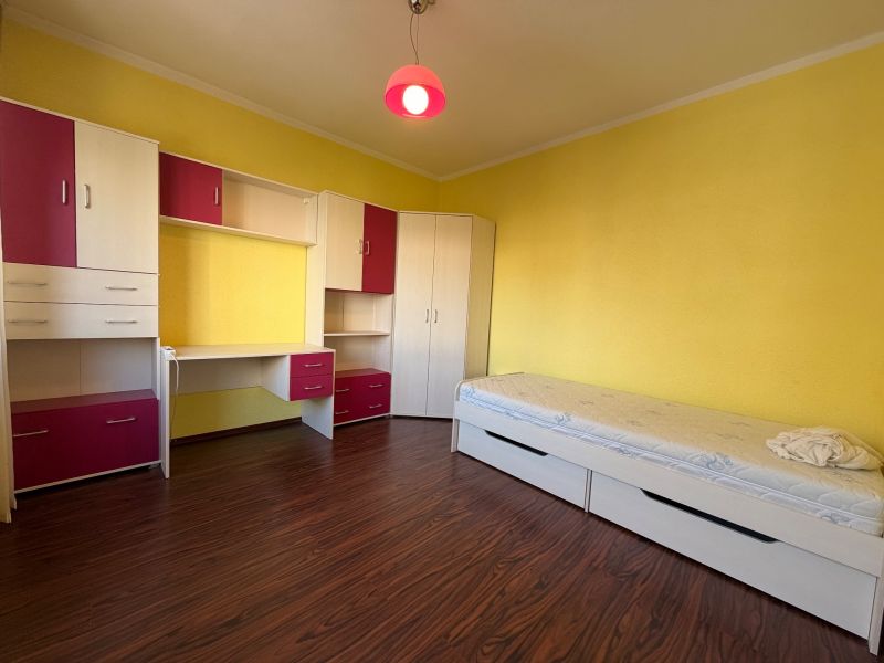Kinderzimmer in einer 3-Zimmer-Wohnung mit gelben Wänden und Möbeln mit Stauraum.