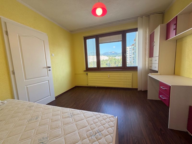 Gelbe Wände des Zimmers mit einem Holzboden in einer 3-Zimmer-Wohnung.