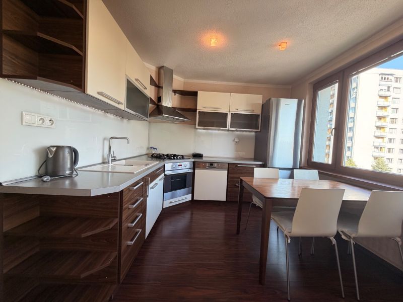 Küche in einer 3-Zimmer-Wohnung mit Holzboden und Esstisch.
