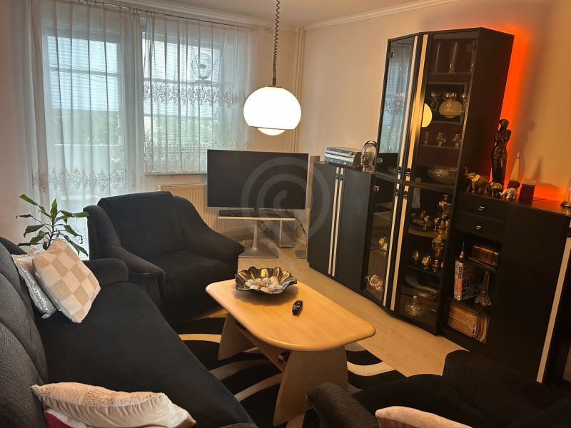 Wohnzimmer in einer 3-Zimmer-Wohnung mit bequemer Sitzecke und Stehlampe.