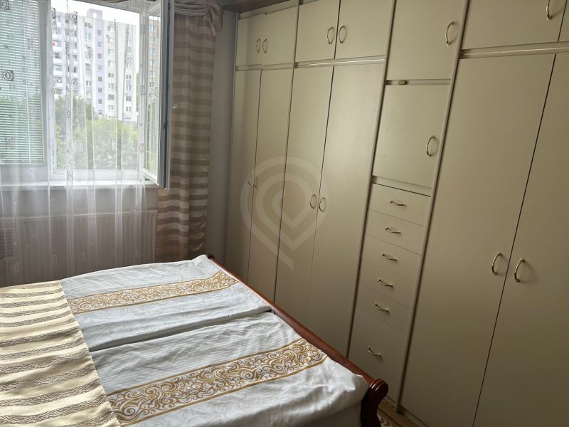 Schlafzimmer in einer 3-Zimmer-Wohnung mit Einbauschränken und einem offenen Fenster mit Blick ins Grüne.