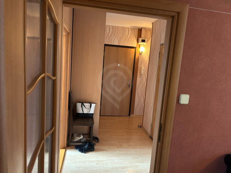 Flur in einer 3-Zimmer-Wohnung mit einem Boden in Holzoptik.