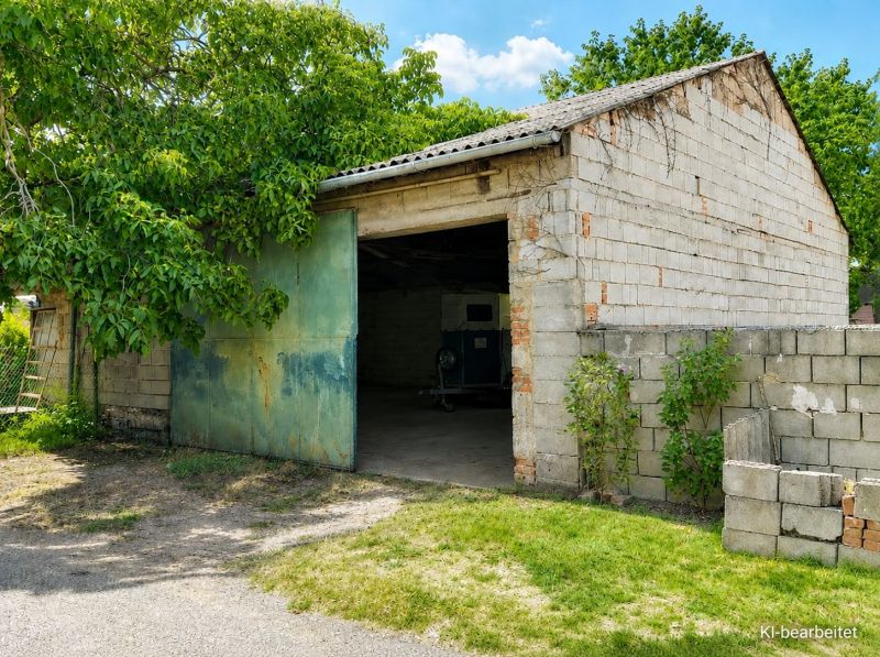 Ein Einfamilienhaus in Illmitz hat eine Ziegelgarage mit grünen Türen und umgebendem Grün.
