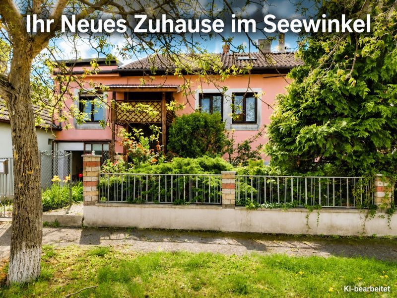 Ein Einfamilienhaus in Illmitz mit rosa Fassade und einem grünen Vorgarten voller Pflanzen.