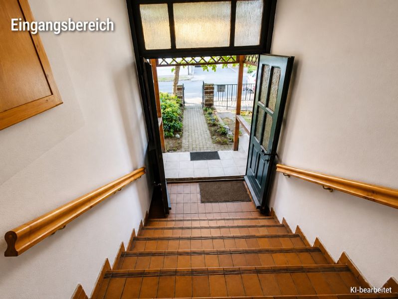 Eine Treppe in einem Einfamilienhaus mit Blick auf den Garten durch die offenen Türen.