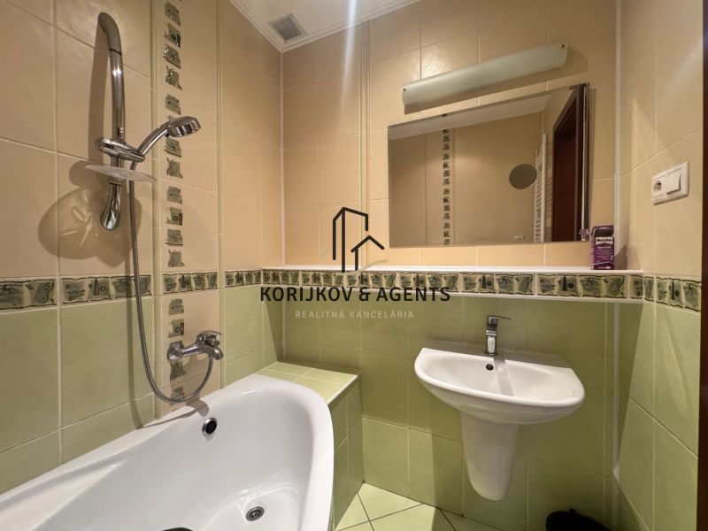 Badezimmer in einer 4-Zimmer-Wohnung mit Badewanne, Waschbecken und Spiegel.
