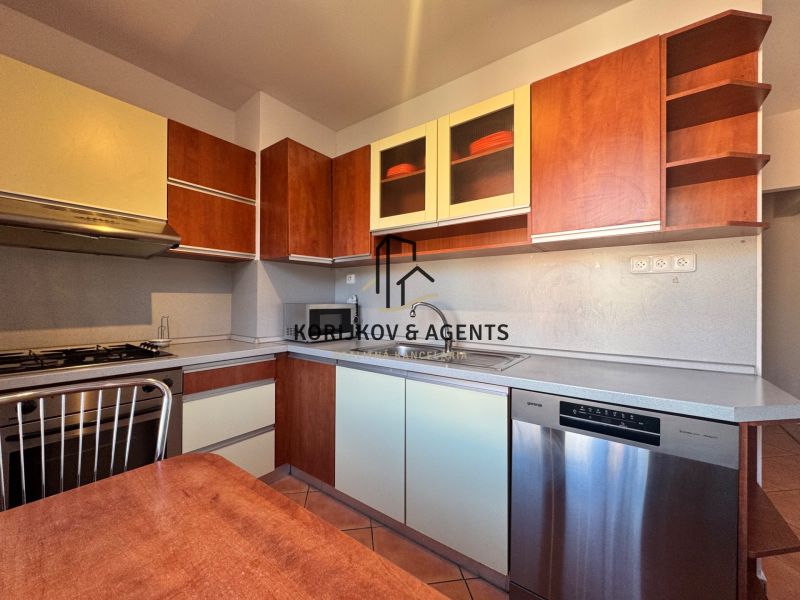 Küche in einer 4-Zimmer-Wohnung mit Geschirrspüler und Küchenzeile mit Holzdekor.