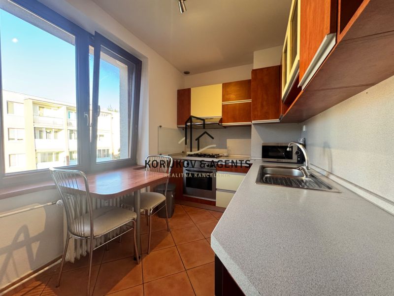 Küche in einer 4-Zimmer-Wohnung mit Fliesen und Küchenzeile.