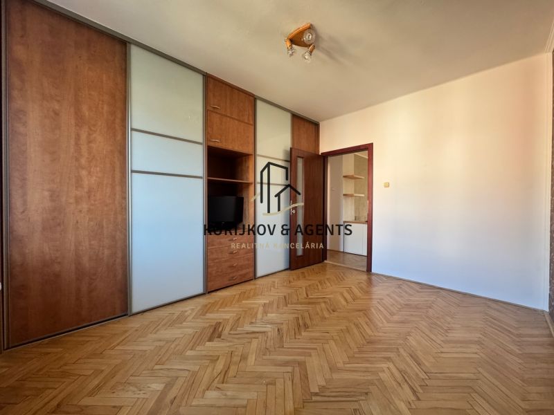Ein Zimmer in einer 4-Zimmer-Wohnung mit Holzboden und Einbauschrank.
