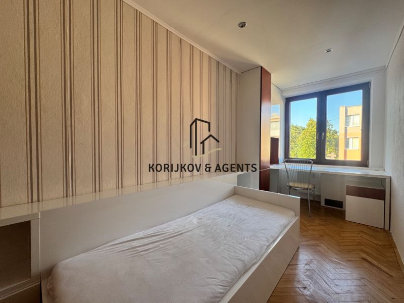 Schlafzimmer in einer 4-Zimmer-Wohnung mit Holzboden und Schreibtisch.