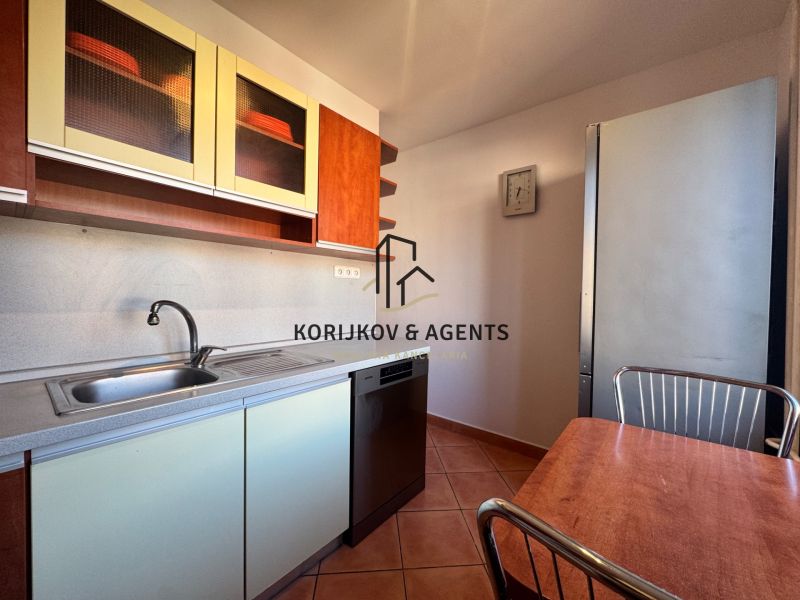 Küche einer 4-Zimmer-Wohnung mit Küchentisch, Geschirrspüler und Schränken mit Holzdekor.
