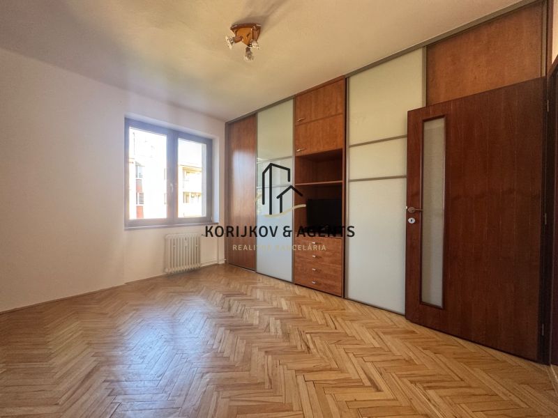 Ein Zimmer mit einem Einbauschrank und einem Boden in Holzoptik in einer 4-Zimmer-Wohnung.