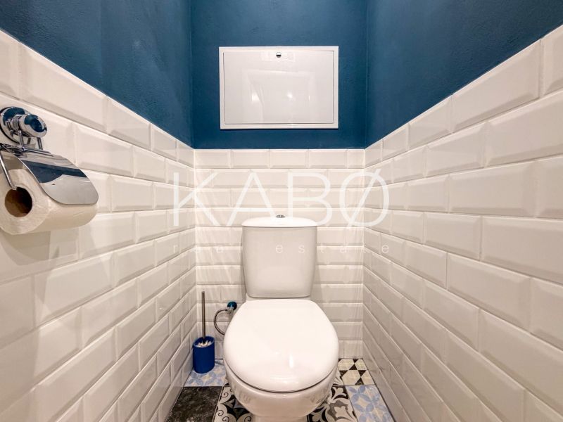 Badezimmer in einer 2-Zimmer-Wohnung mit weißen Fliesen und dunkelblauen Wänden.