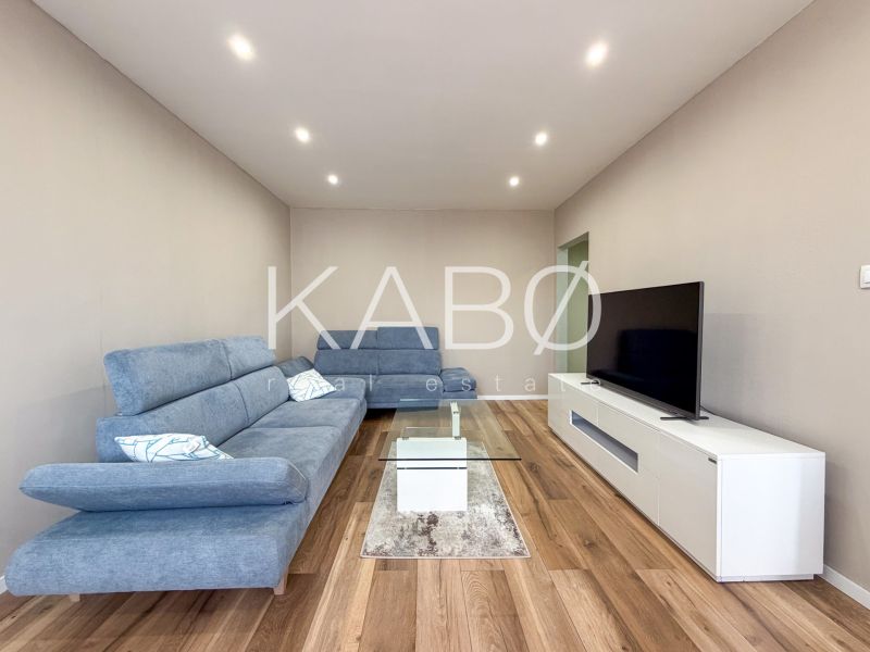Wohnzimmer in einer 2-Zimmer-Wohnung mit Holzboden und modernen Möbeln.