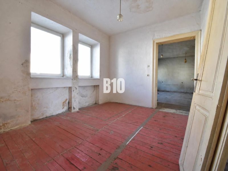 Ein Zimmer in einem Einfamilienhaus mit Holzboden und einfacher Einrichtung.