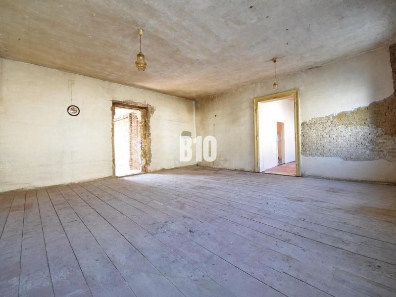 Geräumiges Zimmer mit Holzboden in einem Einfamilienhaus, geeignet für Renovierung.