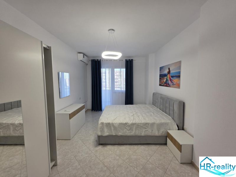 Schlafzimmer in einer 2-Zimmer-Wohnung mit Bett, weißen Möbeln und einem Bild an der Wand.