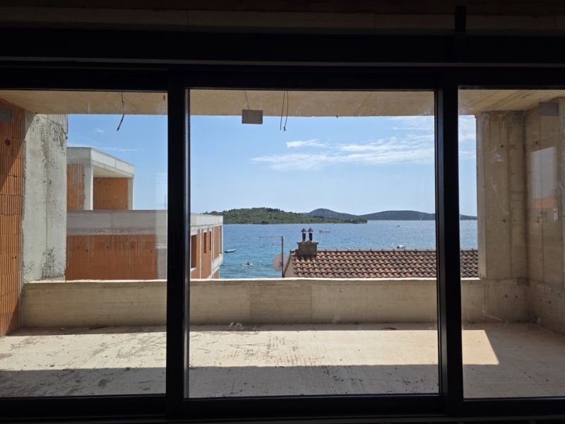 Blick aus einer 3-Zimmer-Wohnung in Srima auf das Meer durch ein großes französisches Fenster.