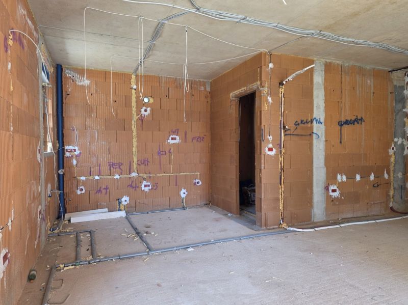 Bau einer 3-Zimmer-Wohnung mit Ziegelwänden und Installation von Leitungen.