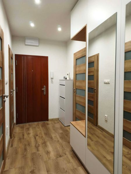 Flur mit Holzboden und Spiegelschrank in einer 3-Zimmer-Wohnung.