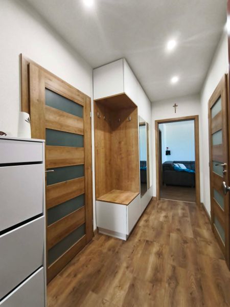 Flur in einer 3-Zimmer-Wohnung mit einem Boden in Holzoptik und Holztüren.