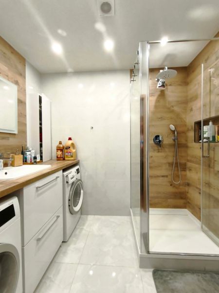 Badezimmer in einer 3-Zimmer-Wohnung, Duschkabine mit Boden in Holzoptik.