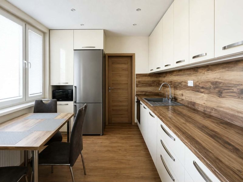 Küche in einer 3-Zimmer-Wohnung mit Boden und Arbeitsplatte in Holzoptik.
