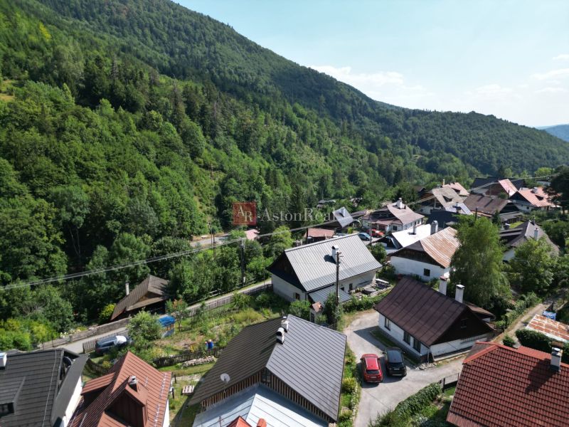 Ein Blick auf die malerischen Hütten in Špania Dolina in der Nähe von Banská Bystrica, umgeben von dichten Wäldern.