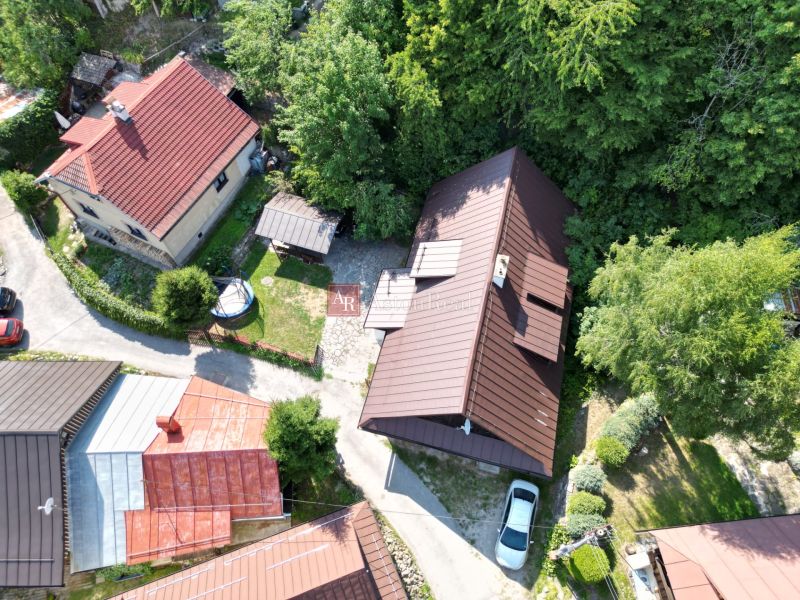 Luftaufnahme einer Hütte in Špania Dolina bei Banská Bystrica, umgeben von Grün und Häusern.