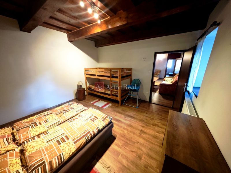 Ein Zimmer in einer Hütte mit einem Etagenbett, einem Boden in Holzoptik und Deckenbalken.