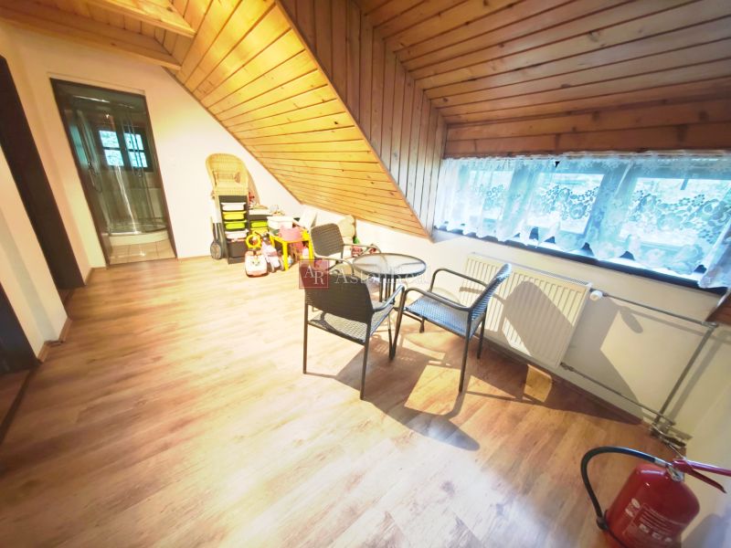 Boden mit Holzdekor, Sitzgelegenheiten, Kinderspielzeug und schräges Dach in der Hütte.