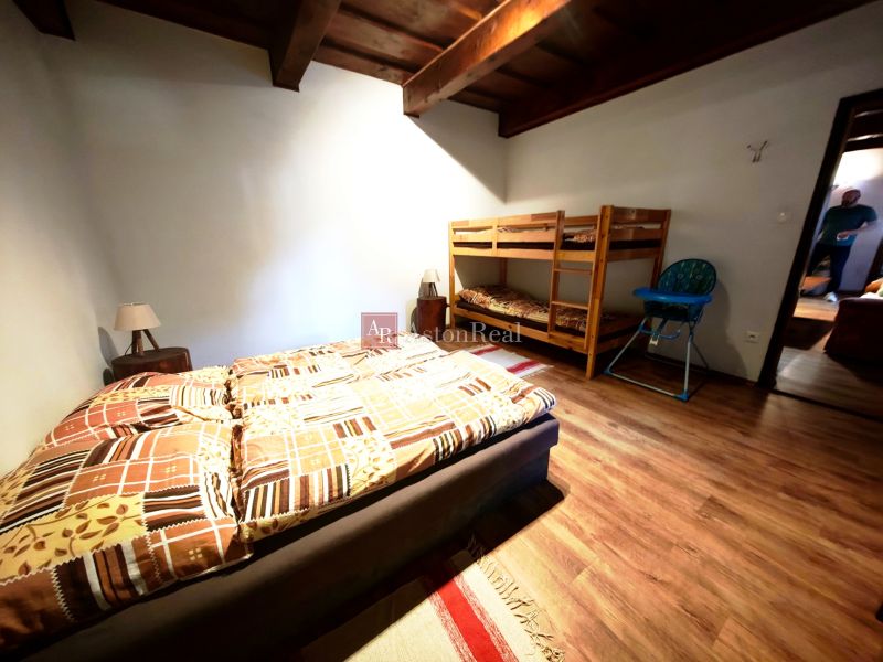 Schlafzimmer in der Hütte mit Doppelbett, Etagenbett und Boden mit Holzdekor.