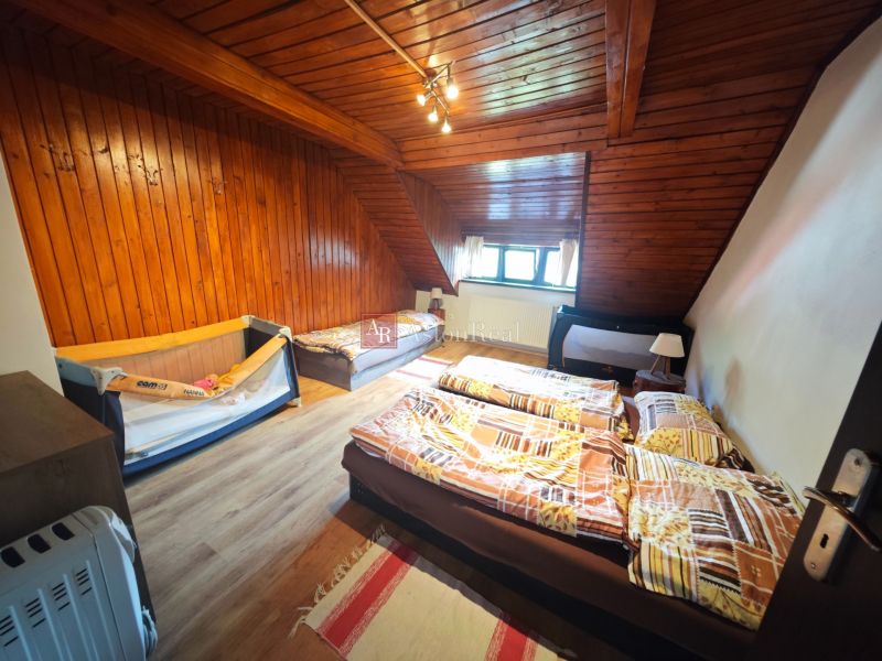 Ein Dachzimmer in einer Hütte mit Holzverkleidung und einem Boden mit Holzdekor.