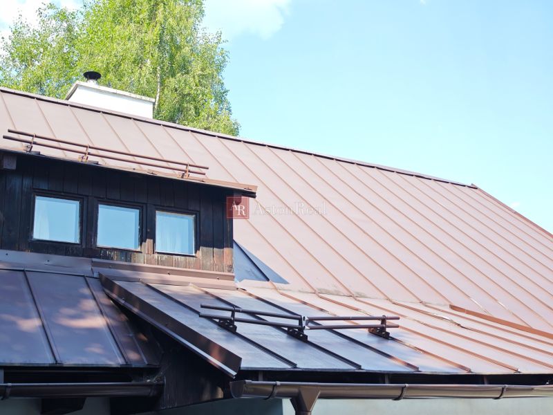 Eine Hütte in Špania Dolina mit einem Blechdach und Holzelementen.