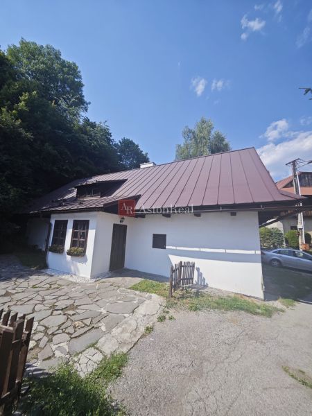 Ein Familienhaus in Špania Dolina mit einem Steinweg und einem Holzzaun, umgeben von Natur.