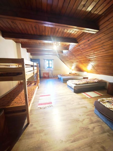 Ein Dachzimmer in einer Hütte mit Betten und einem Boden in Holzoptik.