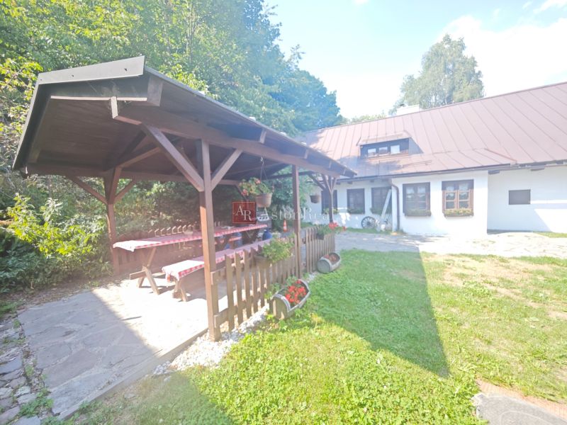 Eine Hütte in Špania Dolina mit einem Pavillon, einem Holztisch und Blumenschmuck im Garten.