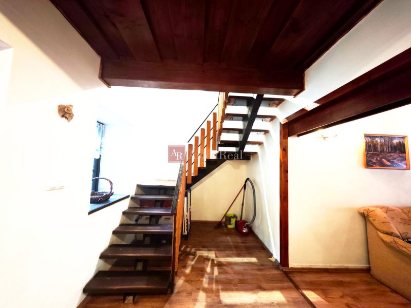 Das Innere der Hütte mit einer Holztreppe und einem Boden mit Holzdekor.