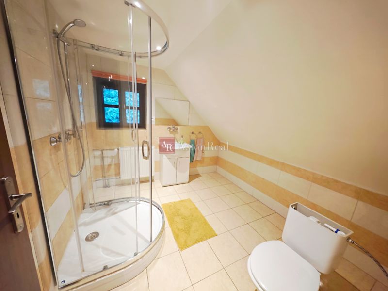 Ein Badezimmer in der Hütte mit einer Eckdusche und Blick auf das Fenster.