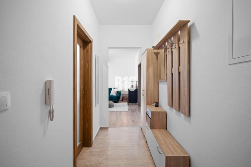 Der Flur in der 2-Zimmer-Wohnung mit Möbeln und Zugang zum Wohnbereich.